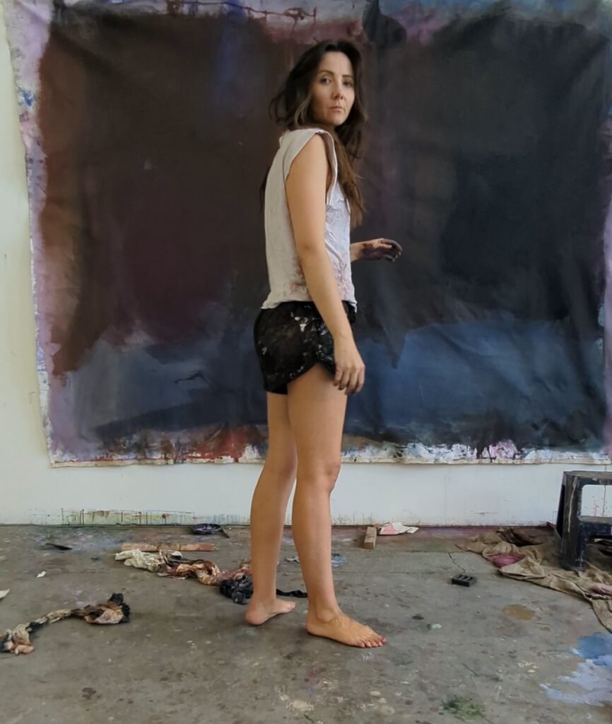 Perth abstract artist Kate Dolan with large scale original paintings in her Fremantle studio.