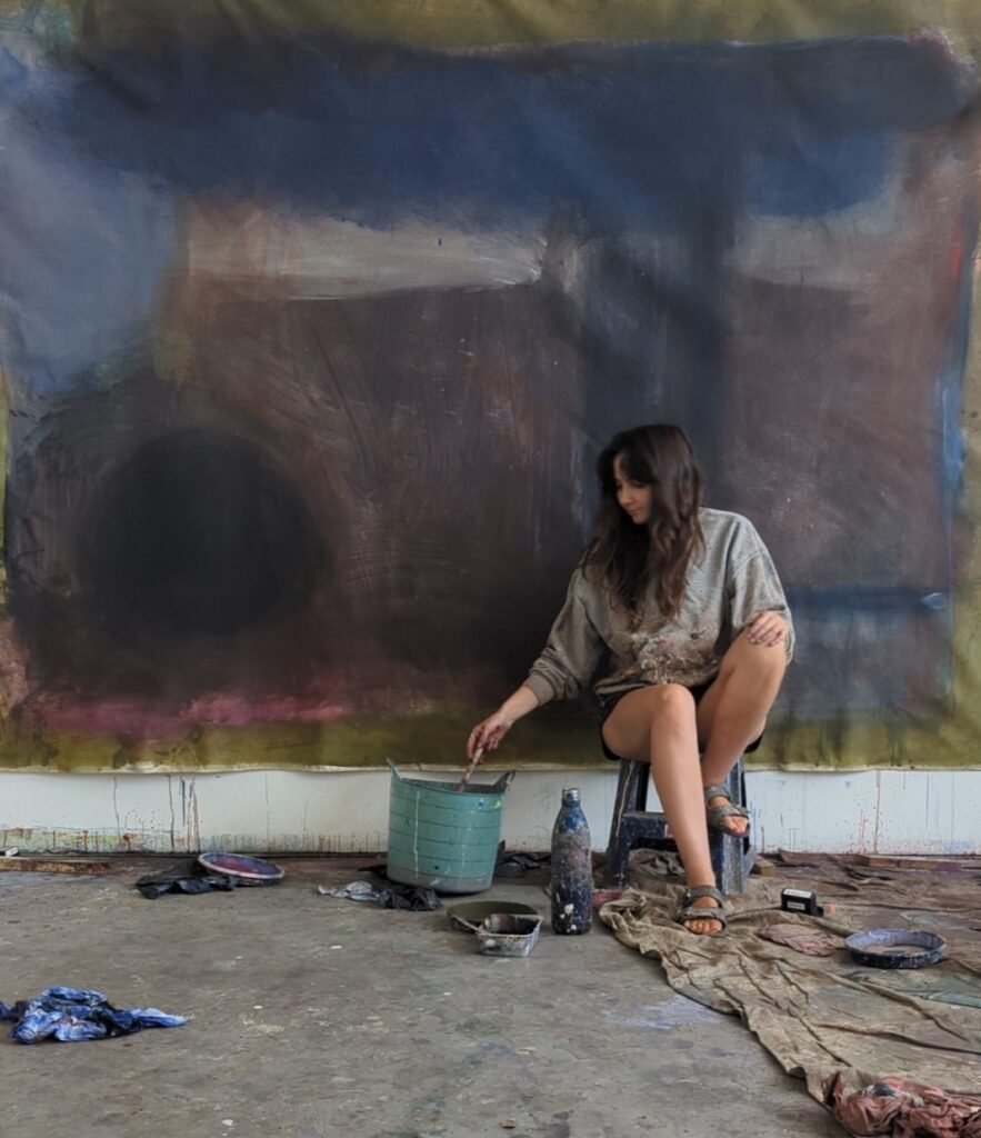 Kate in the studio with a large-scale abstract painting from her 'Zero' series